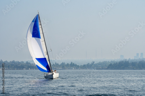 Foto Sailboat sailing spinnaker on smoke filled hazy sky day north of Seattle in Puget Sound