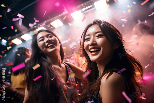two young asian girls dancing in the nightclub. party and concert advertising campaign background.