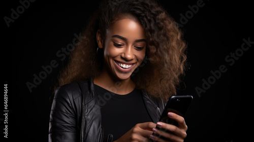 Happy smiling young woman is using her phone on a colored background.