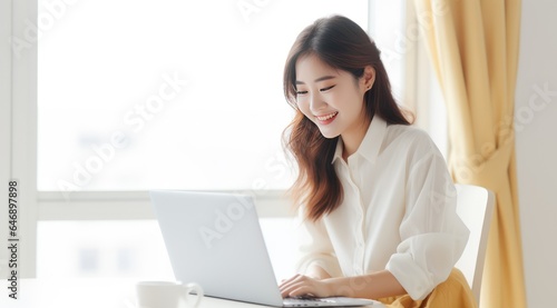 A Smiling Japanese Woman Working on Laptop in Office 