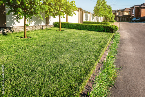 Perfect green grass lawn and asphalt road