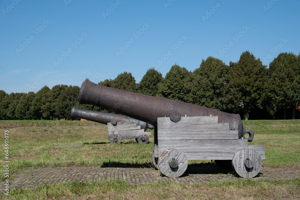 old canon on brick wall, along the river, Dutch landscape of fortified city Heusden, blue sky