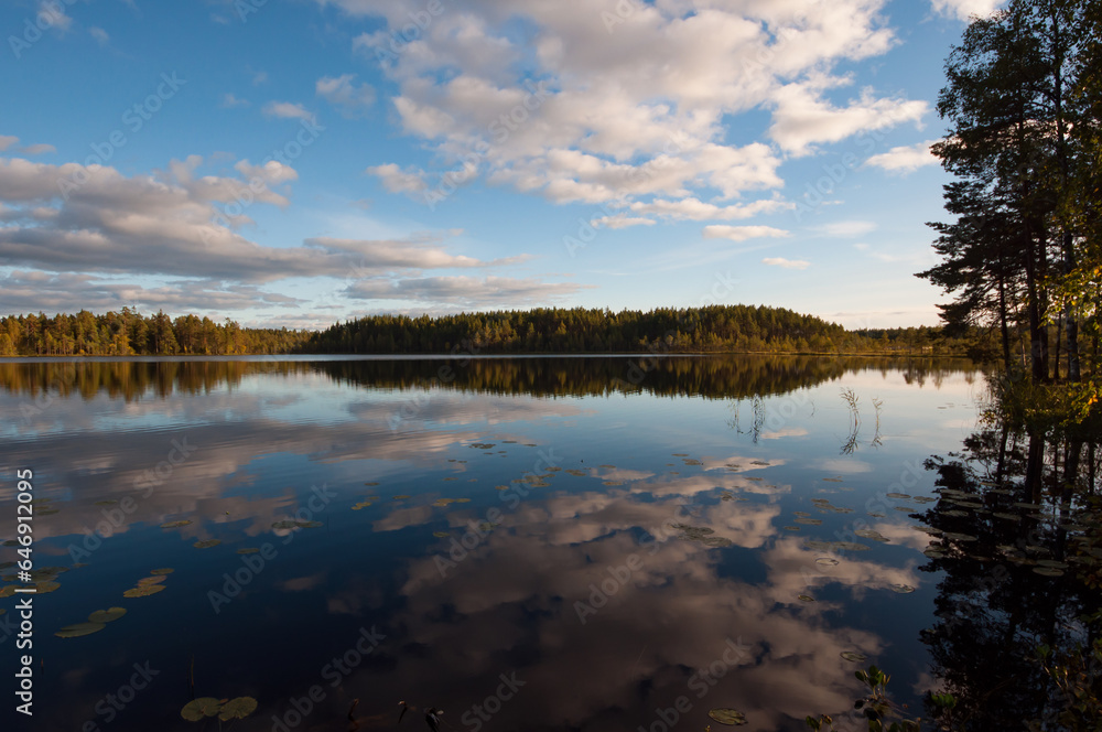 Autumn lake scenery with clouds reflected on the surface of water in the forests of Finland