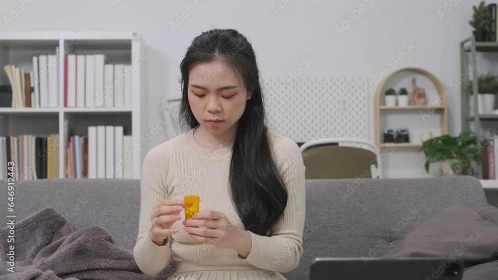 Sick young asian woman pouring pill from bottle, taking medicine to relieve pain. Healthcare, medical supplements concept Sick young asian woman pouring pill from bottle, taking medicine to relieve pain. Healthcare, medical supplements concept