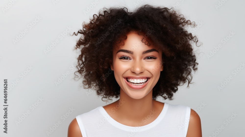 young trendy beautiful mixed race woman with an afro smiling and posing on white background
