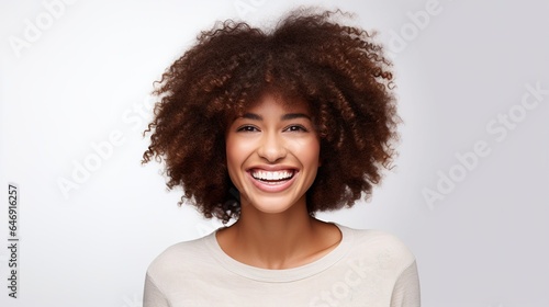 young trendy beautiful mixed race woman with an afro smiling and posing on white background