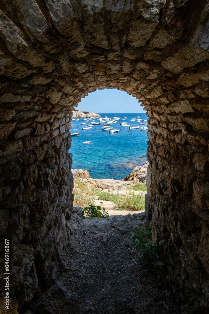Natural framing of the Mediterranean Sea with boats anchored in its waters along the Costa Brava.