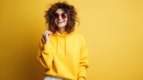 woman wearing sunglasses on yellow studio background