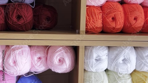 Many colorful balls of wool yarn in a fabric store. Background from colored cotton yarn. Vertical  photo