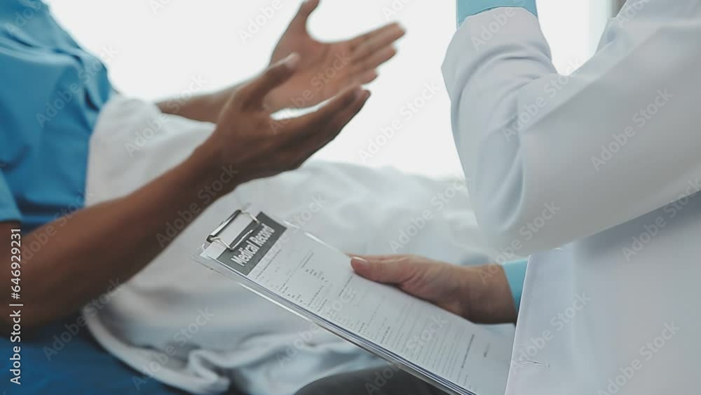 Senior doctor and young male patient who lie on the bed while checking pulse, consult and explain with nurse taking note and supporting in hospital wards. Senior doctor and young male patient who lie on the bed while checking pulse, consult and explain with nurse taking note and supporting in hospital wards.