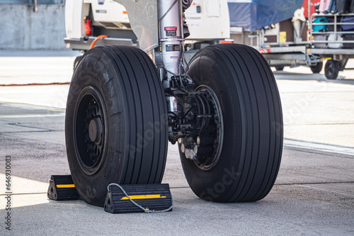 Detailed view of commercial aircraft main landing gear. Airplane wheels with tires on airport runway. © Victor