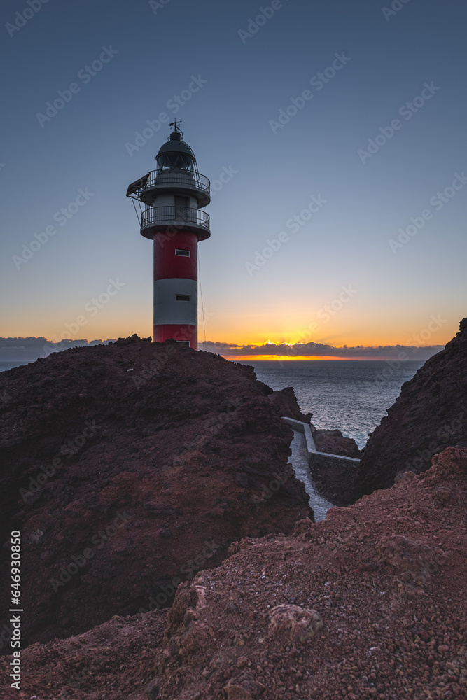 lighthouse at sunset on a seashore