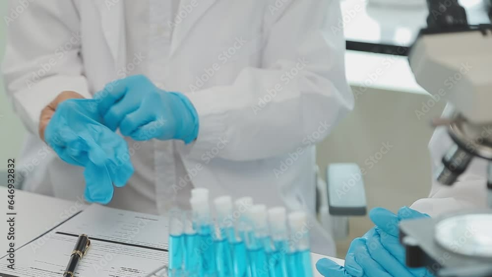 Health care researchers working in life science laboratory. Young female research scientist and senior male supervisor preparing and analyzing microscope slides in research lab. Health care researchers working in life science laboratory. Young female research scientist and senior male supervisor preparing and analyzing microscope slides in research lab.
