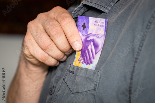 Принти на полотні The man takes a thousand Swiss francs out of his shirts pocket, the highest deno