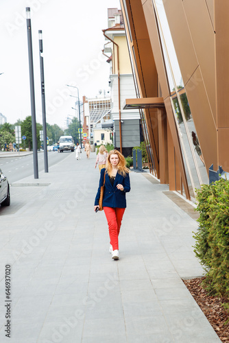 woman walking on street. female woman in casual style clothes with long hair on city street. interior designer, architect, businesswoman