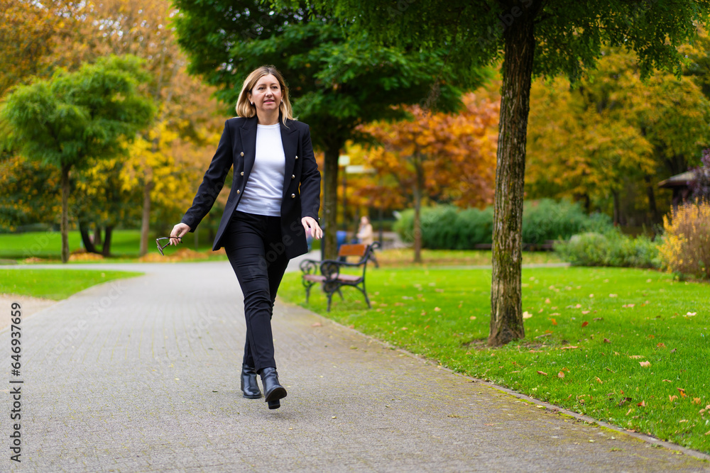 Beautiful businesswoman walking in city park
Beautiful businesswoman walking in city park