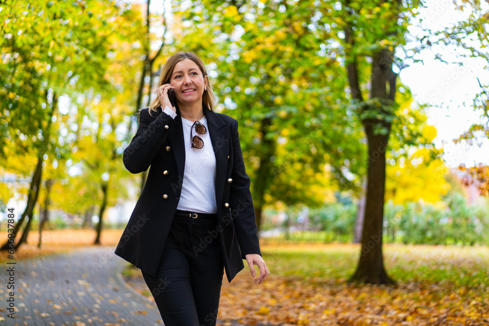 Beautiful woman talking on the phone walking in autumn park
Beautiful woman talking on the phone walking in autumn park