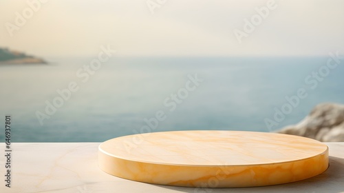 Round Marble Podium in light yellow Colors in front of a blurred Seascape. Luxury Backdrop for Product Presentation 