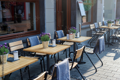 tables in street outdoor cafe with nature decoration