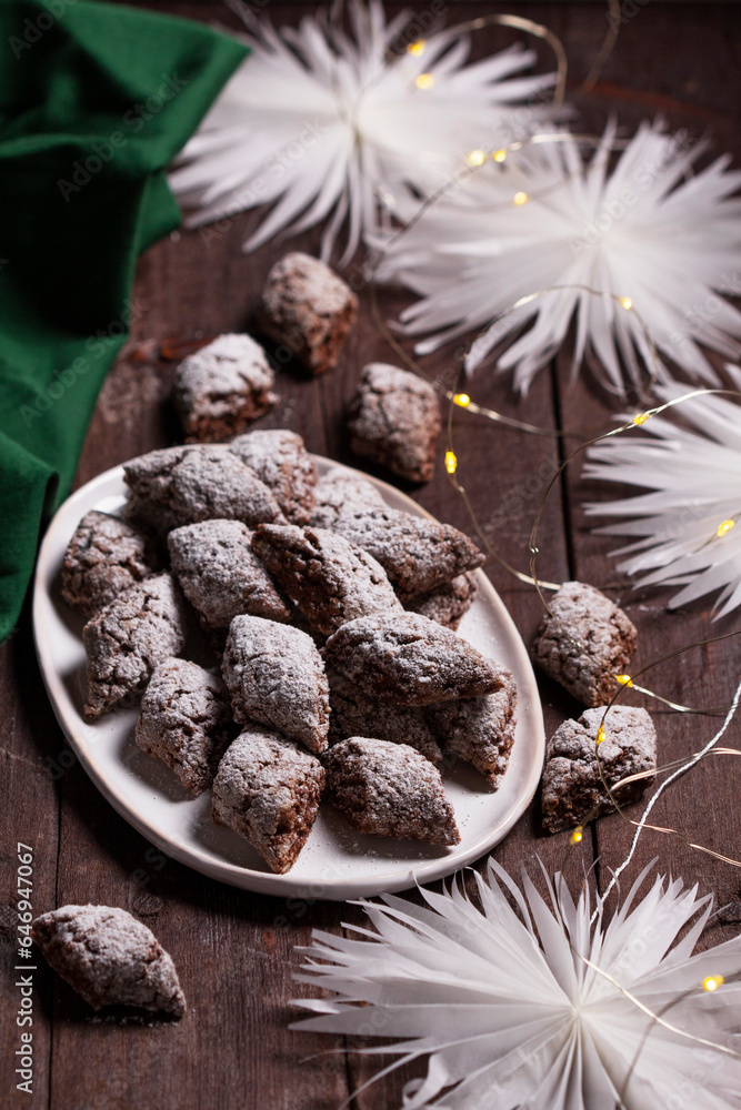 Italian Christmas cookies Castagnelle with almonds, cocoa and egg whites on a wooden background. Gluten free cookies.