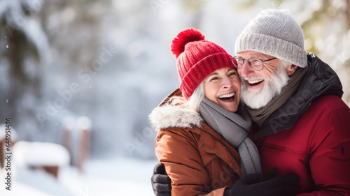 Senior couple enjoying life outdoors in winter. Beautiful woman and handsome man laughing and looking each other. There is romance in the air. Blurry background.