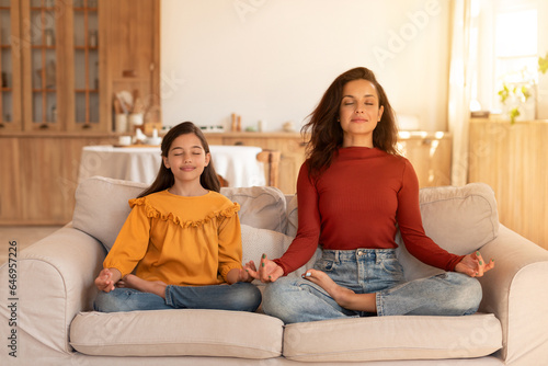 Peaceful Arabic Mom And Daughter Doing Yoga Together Meditating Indoor