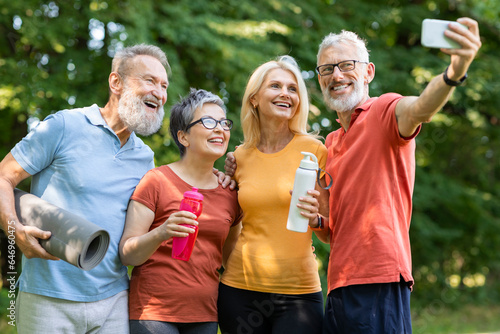 Group of happy senior people taking selfie on smartphone after outdoor training