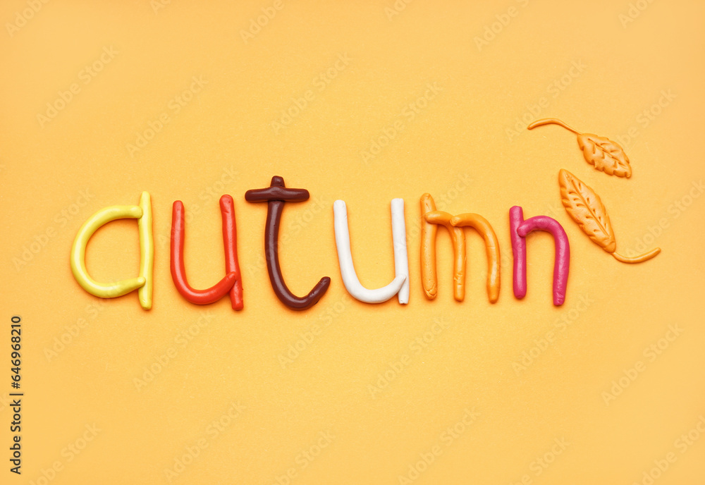 Word AUTUMN made of play dough on orange background Word AUTUMN made of play dough on orange background