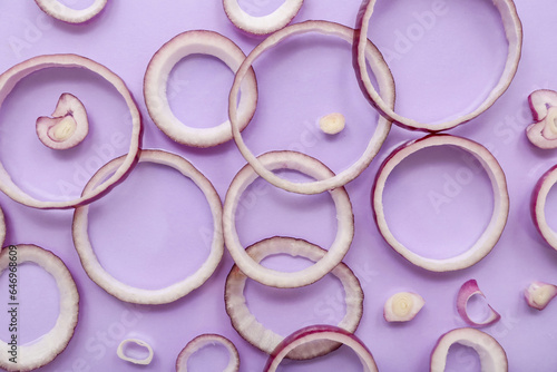 Slices of fresh red onion on lilac background