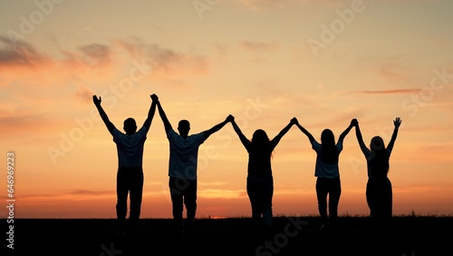 Team of people look at their future together at sunset, park. Group of business people outdoors raise their hands to sky. Human resources. Community of people joint prayer. Unity of group of people