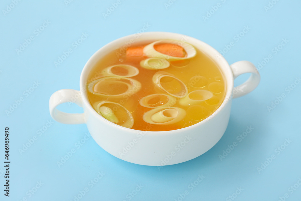 Pot of tasty vegetable broth on blue background Pot of tasty vegetable broth on blue background