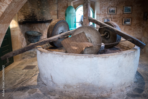 Old mill for grinding olives. An antique machine for producing olive oil.