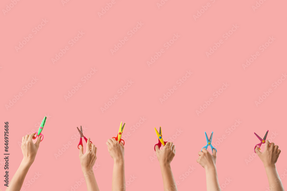 Many hands with paper scissors on pink background Many hands with paper scissors on pink background