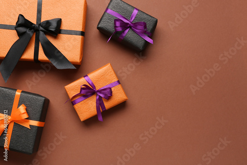 Different gifts for Halloween celebration on color background