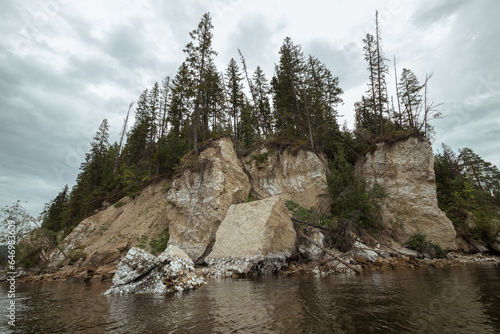 view of the rocky cliff of the river bank from the river side.
