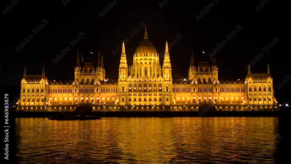 The Parliament in Budapest, Hungary, lit up on a dark winter night, the Danube River in the foreground The Parliament in Budapest, Hungary, lit up on a dark winter night, the Danube River in the foreground
