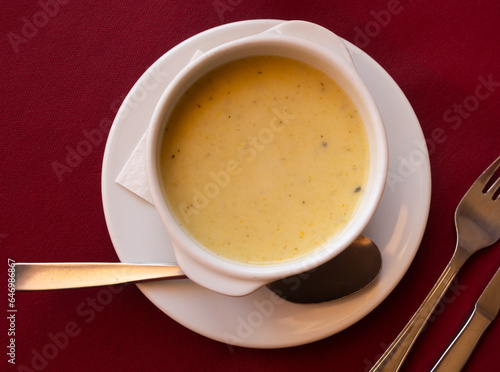 In deep ceramic plate, delicate cream soup is mashed from seasonal farm vegetables.