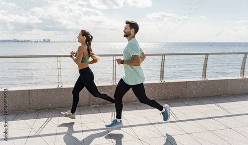Runners athletes in fitness clothes. Beautiful jogging in sports shoes. Motivation for a healthy lifestyle. Cardio endurance exercises, use a fitness watch and an app.