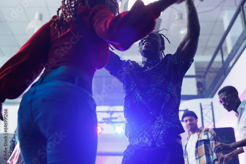 Photos Carefree man and woman dancers improvising dance moves to music rhythm at nightclub discotheque