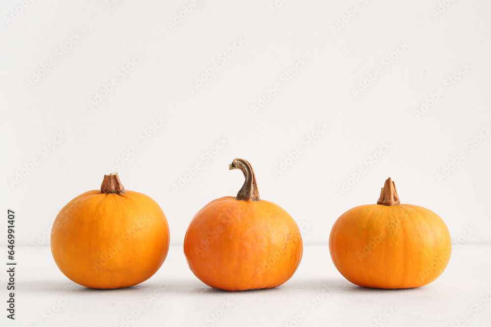 Raw pumpkins for Halloween celebration on light background Raw pumpkins for Halloween celebration on light background