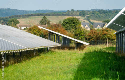 Solar Farm panels,and rural residential buildings in the near distance, the Cotswolds, Gloucestershire,England,United Kingdom.