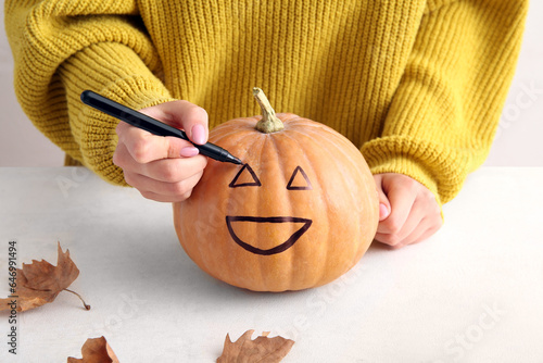 Woman painting pumpkin for ...