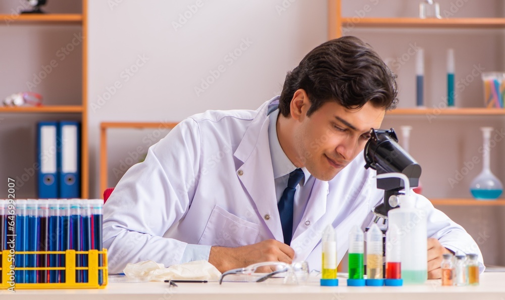 Young handsome biochemist working in the lab Young handsome biochemist working in the lab