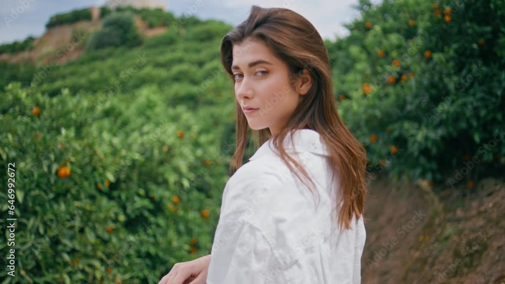 Seductive model gazing shoulder in green slopes portrait. Proud woman posing Seductive model gazing shoulder in green slopes portrait. Proud woman posing
