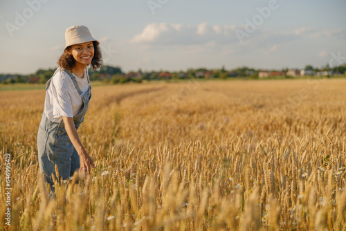 Smiling woman agronomist work in a wheat field and checks the harvest. High quality photo © Kostiantyn