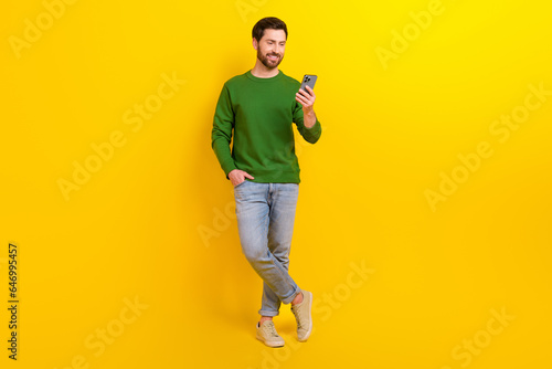 Full body photo of funny professional smm manager content maker blogger young guy hold apple iphone isolated on yellow color background