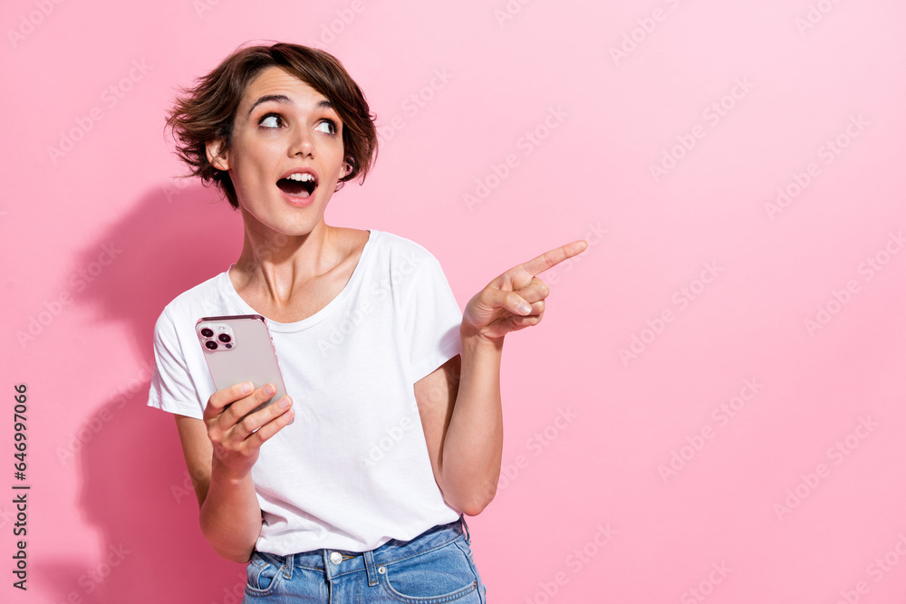 Photo of excited attractive lady wear trendy clothes look offer promo modern technology empty space isolated on pink color background Photo of excited attractive lady wear trendy clothes look offer promo modern technology empty space isolated on pink color background