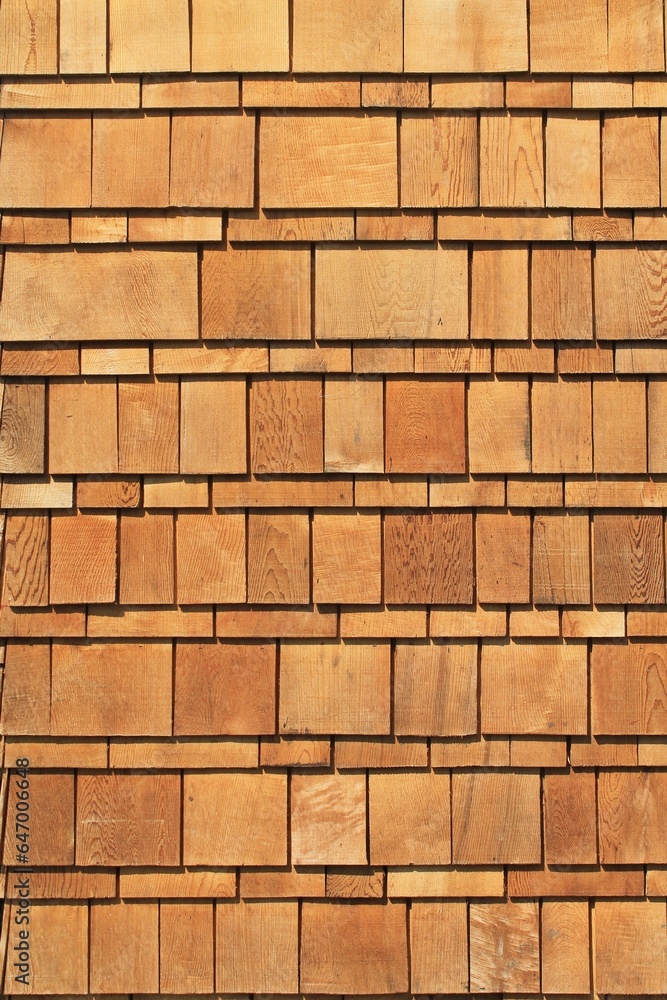 Fototapeta premium Wooden cedar shake siding vertical exterior architecture background pattern