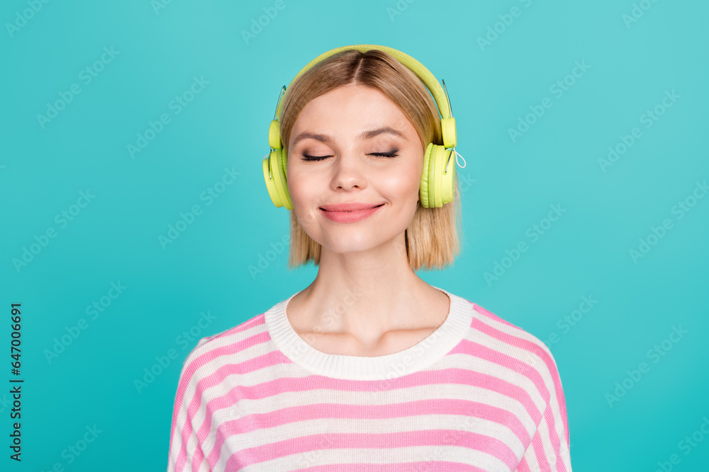 Portrait of young girlfriend wearing striped pink sweater closed eyes satisfied relaxing stereo sound isolated on cyan color background Portrait of young girlfriend wearing striped pink sweater closed eyes satisfied relaxing stereo sound isolated on cyan color background