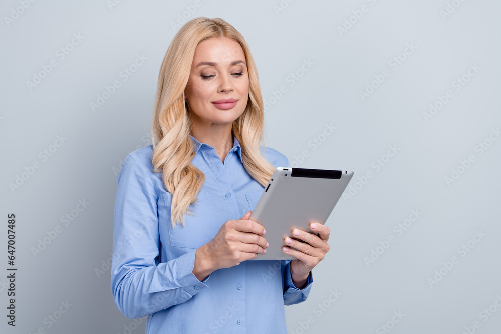 Portrait of pretty successful elegant lawyer use tablet communicate empty space ad isolated on grey color background Portrait of pretty successful elegant lawyer use tablet communicate empty space ad isolated on grey color background